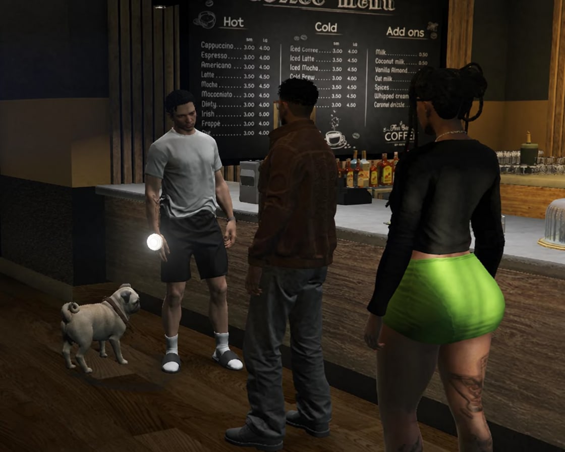 Two men face each other at the coffee shop counter while a pug stands at one man’s feet and a woman looks on