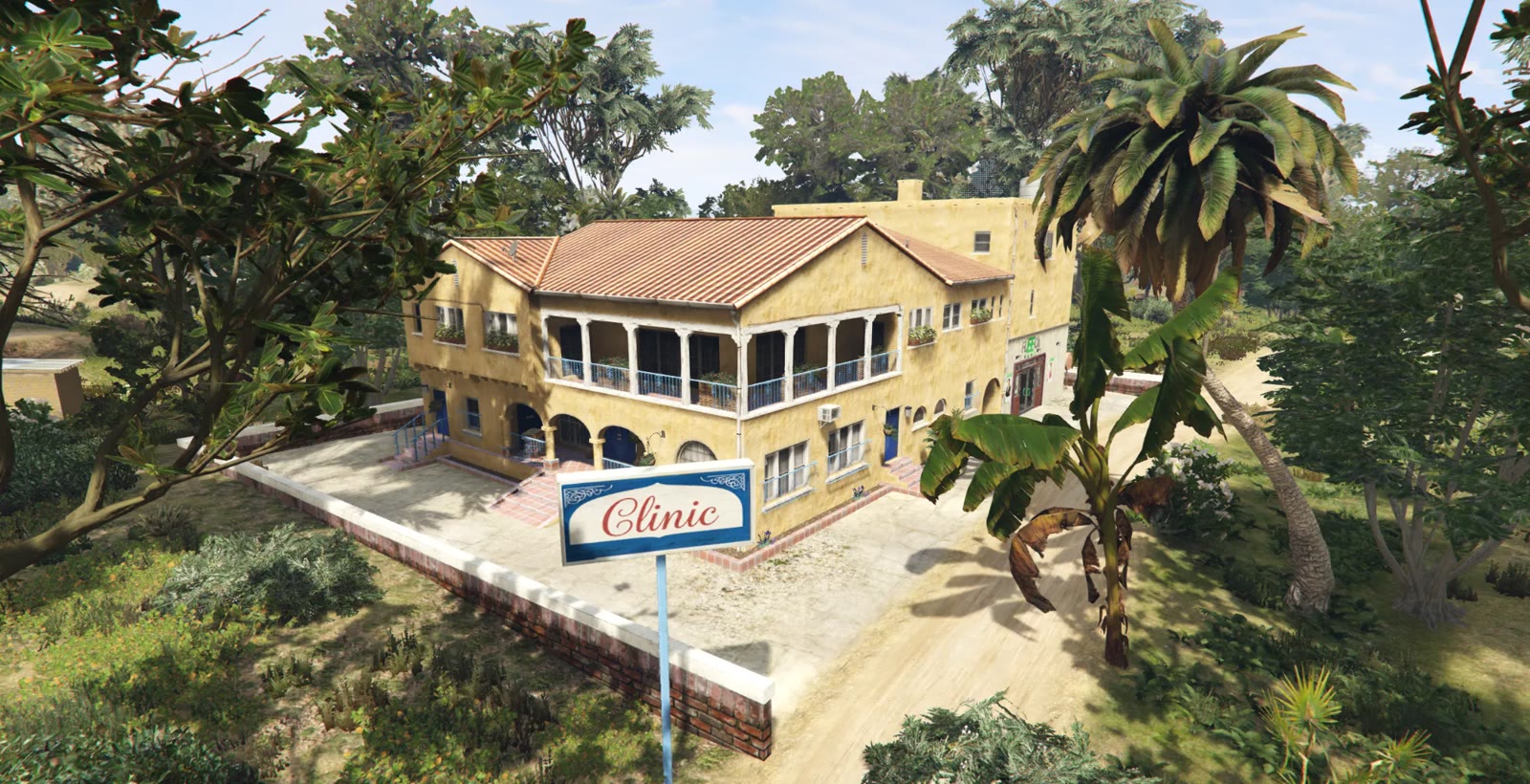 A two-storey sandstone building with a terracotta roof, arched porch and a blue and white sign reading Clinic, surrounded by palms