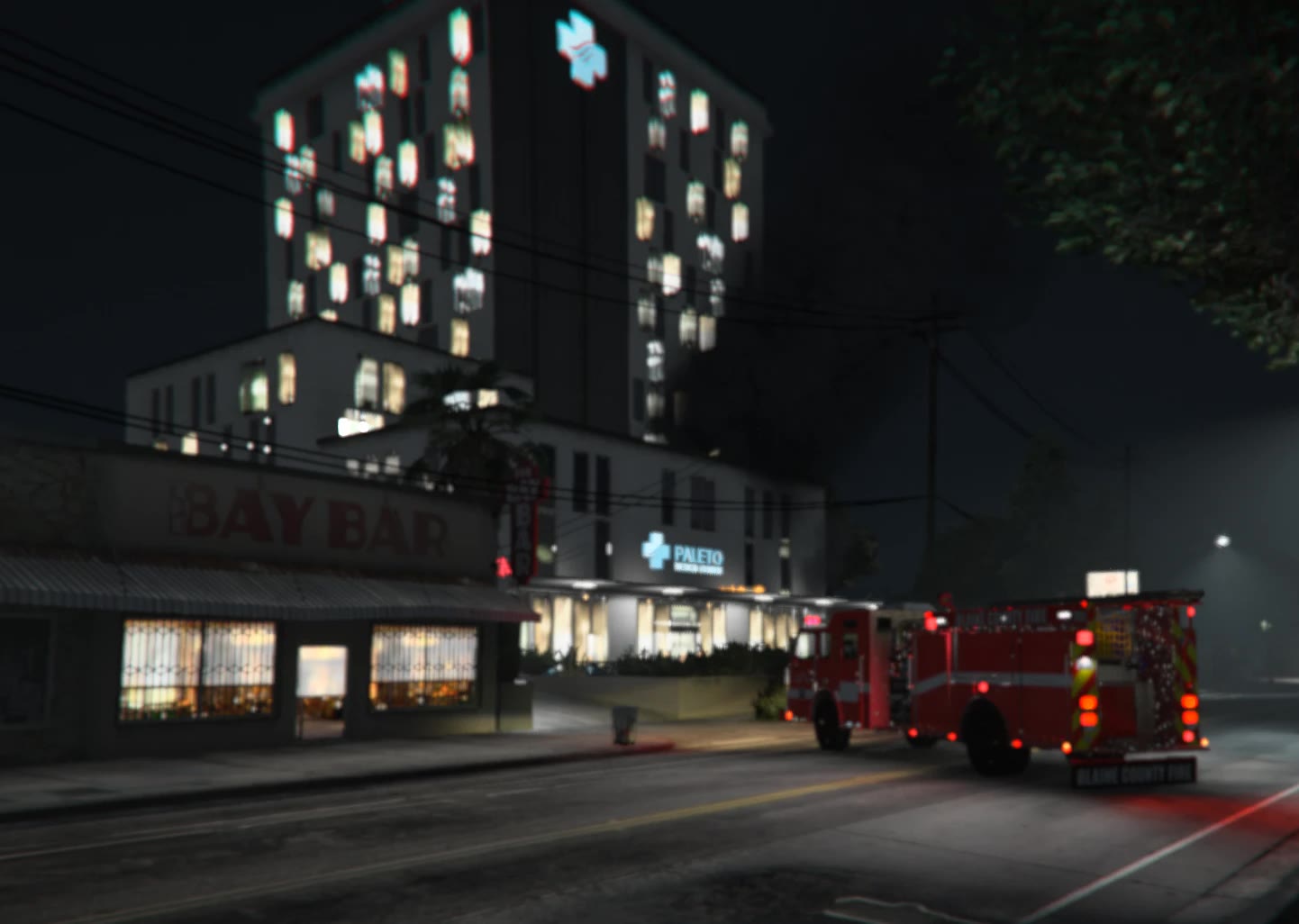Paleto Bay Medical Center at night, with a Blaine County Fire engine parked outside beside the Bay Bar